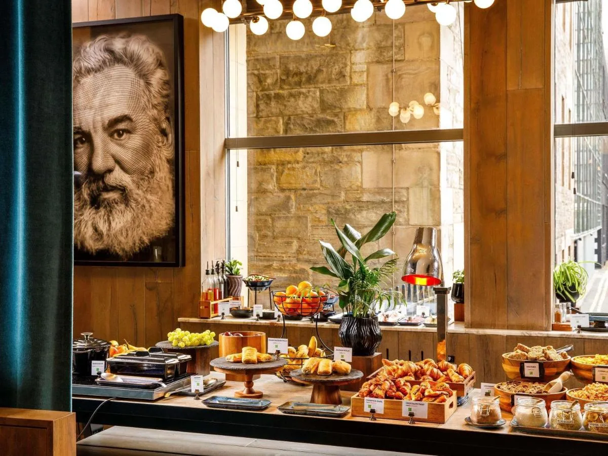 A breakfast buffet with portrait artwork at ibis Styles Edinburgh St Andrew Square