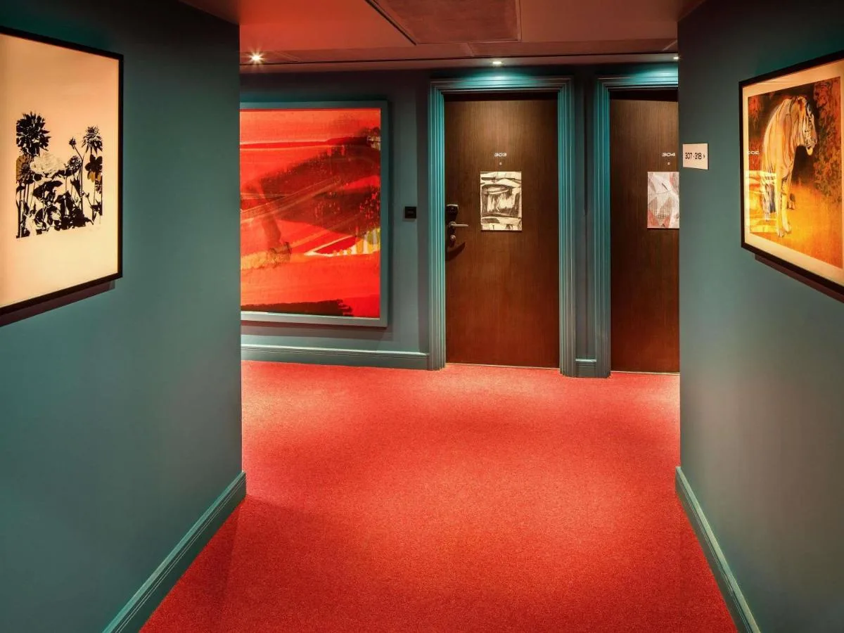 A hallway with a red floor and two doors at ibis Styles Edinburgh St Andrew Square