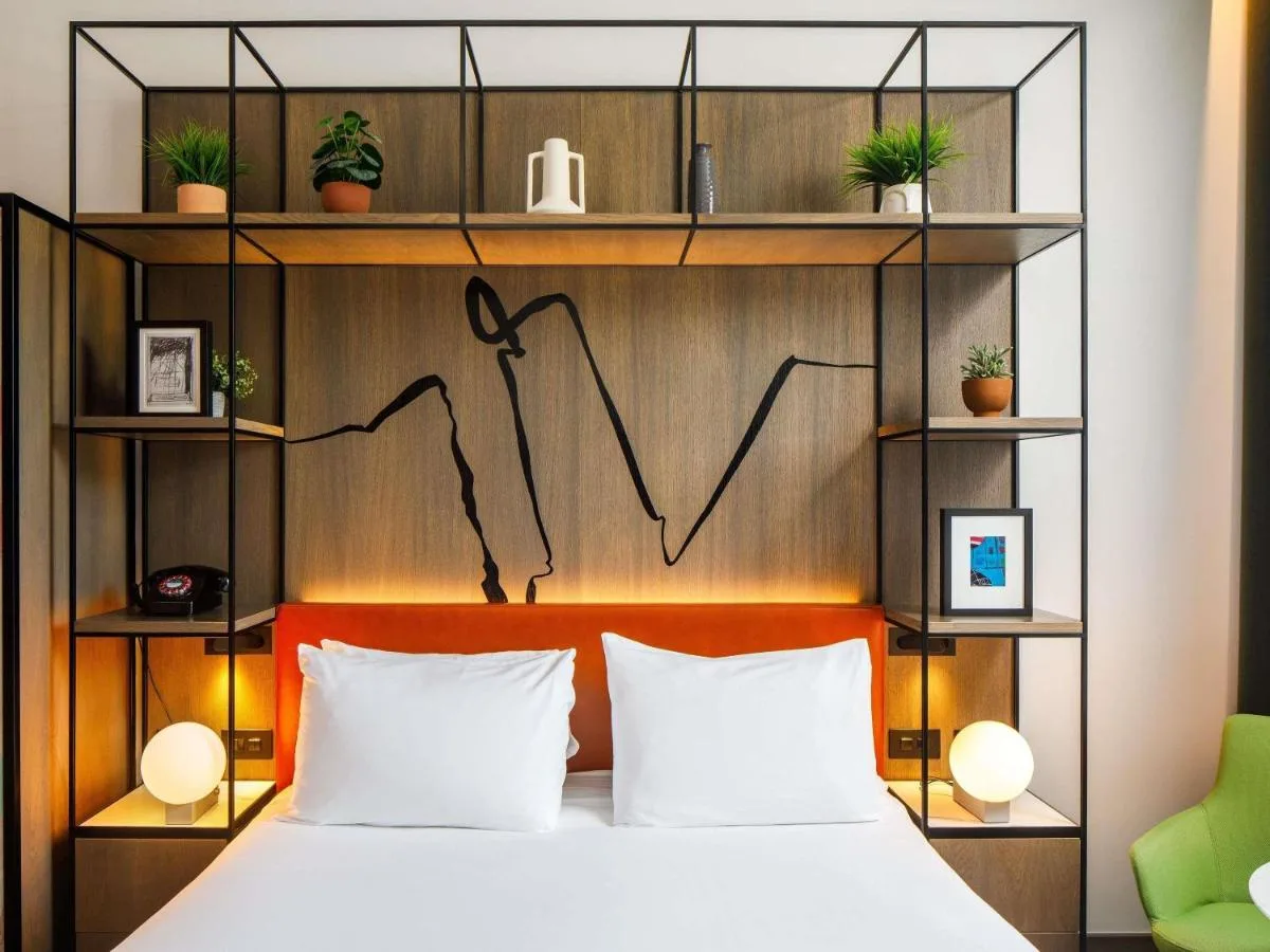 A bedroom with a wooden headboard bed at ibis Styles Edinburgh St Andrew Square