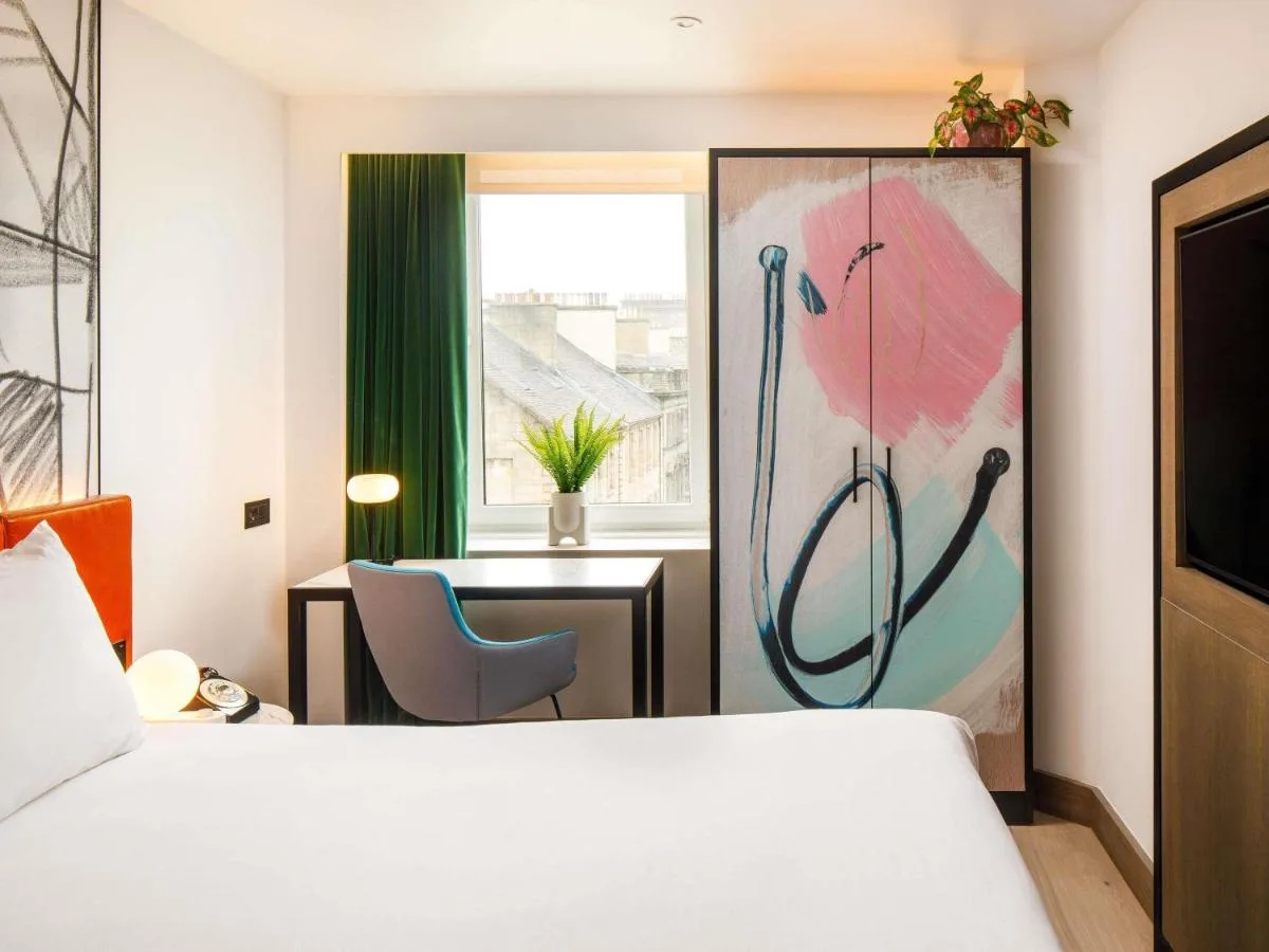 A hotel room with a bed, desk and window at ibis Styles Edinburgh St Andrew Square